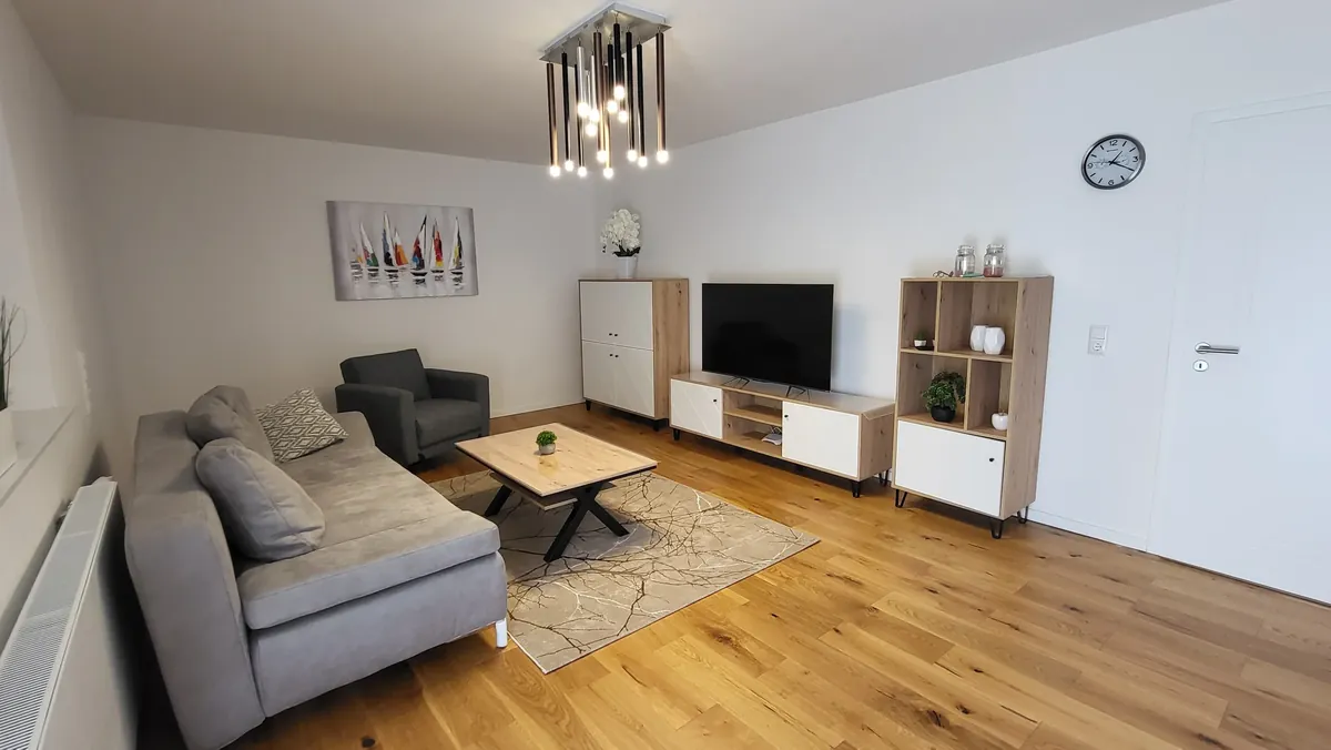 Wohnzimmer mit Parkett, Sofa und Smart-TV – Deluxe Apartment mit Garten, Quiet Apartments Bergisch Gladbach-Refrath