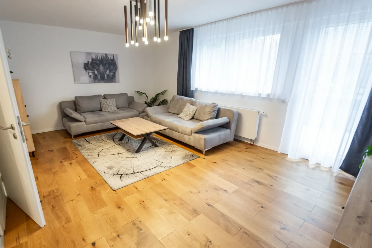 Wohnzimmer mit Parkett, Sofa und großer Fensterfront – Großes Apartment mit Balkon, Quiet Apartments Bergisch Gladbach-Refrath