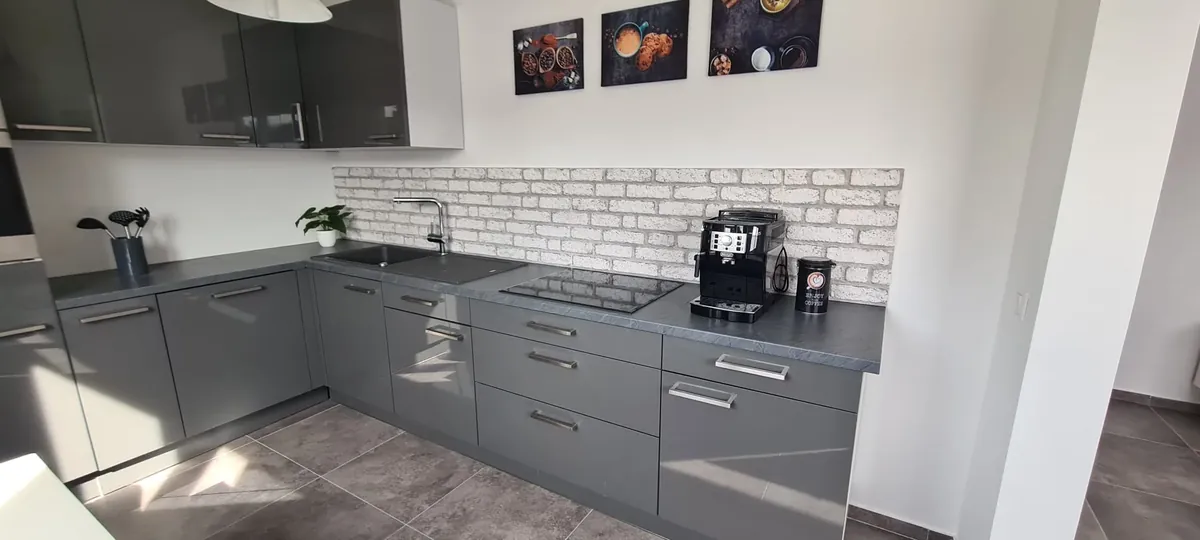 Graue Einbauküche mit Ziegelwand – Modernes Apartment Obergeschoss, Quiet Apartments Bergisch Gladbach-Refrath