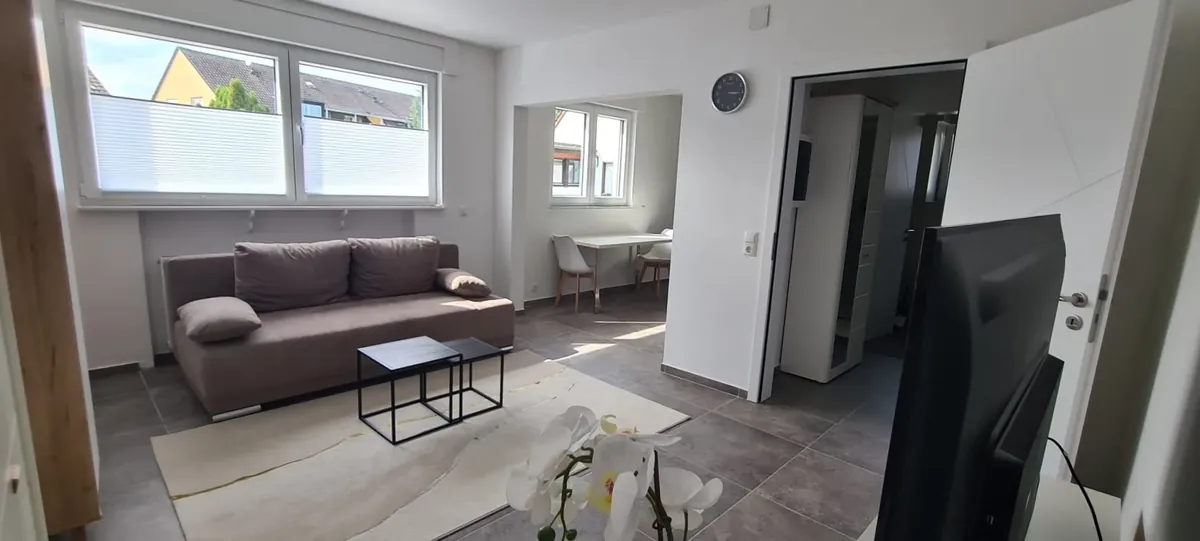 Wohnzimmer mit Fenster und Sofa – Modernes Apartment Obergeschoss, Quiet Apartments Bergisch Gladbach-Refrath